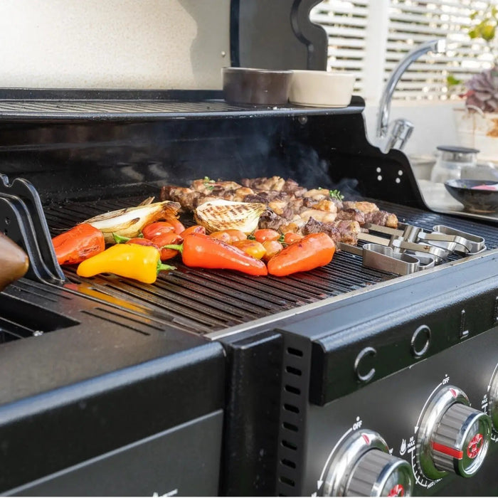 Steak and vegetables cooking on a Coleman barbecue grill